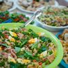 From above homemade appetizing salads and dishes served in bowls on table during family gathering party
